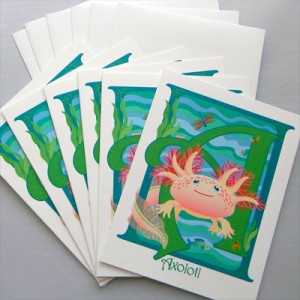 A set of greeting cards. The illustration on the front is an axolotl amphibian swimming in front of the letter A.